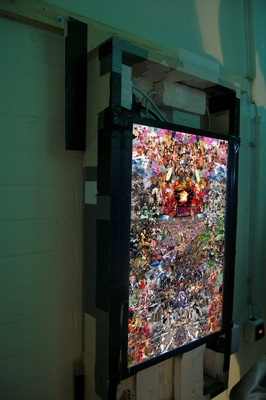 A collage on a flatscreen against the brick wall at Zollverein