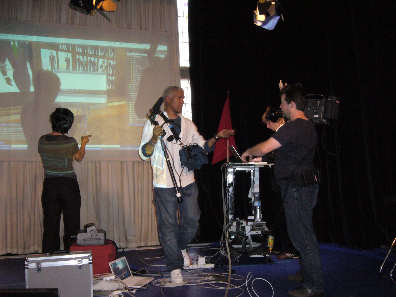 Presenter with microphone and camera team on stage