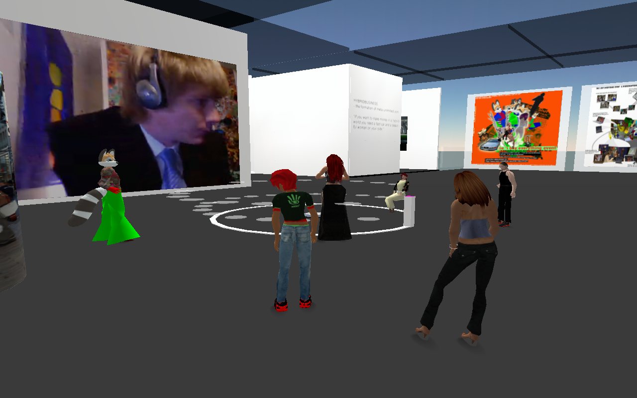 Artist talk in Second Life — the artist as a live webcam feed on the video wall, avatars gathered below